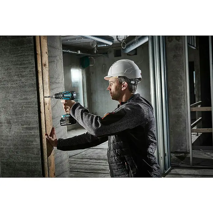 Makita LXT 18V Akku-Schlagschrauber DHP485Z - 18 V, Ohne Akku, 50 Nm - Mann bohrt mit einem blau-schwarzen Makita Bohrer in Holz.
