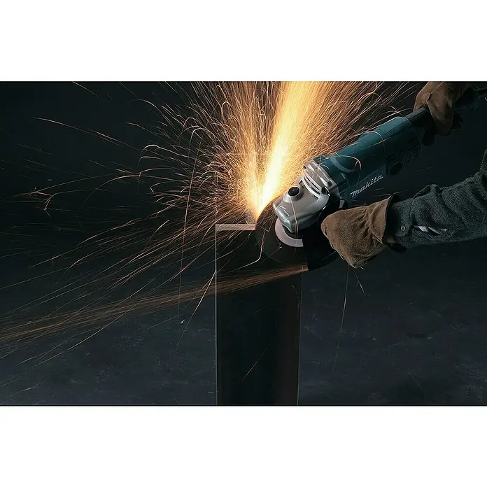 Makita Elektro-Winkelschleifer GA7050R - 2.000 W, Durchmesser Scheibe: 180 mm, Leerlaufdrehzahl: 8.500 U/min - Eine Person mit Handschuhen bedient einen teal-silbernen Winkelschleifer, der beim Trennen von Metall helle Funken erzeugt.