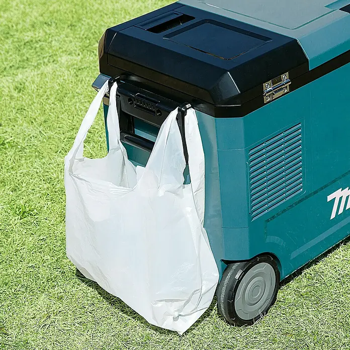 Makita Akku-Kühlbox zum Kühlen & Warmhalten CW004GZ - 18 V, Ohne Akku, 29 l - Türkiser und schwarzer Kühlbox mit Rollen, an dessen Seitenhaken eine weiße Plastiktüte hängt.