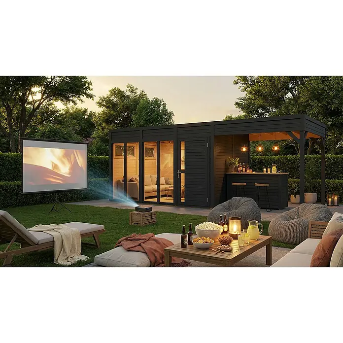Bertilo Gartenhaus Cubus 3 - Außenmaß inkl. Dachüberstand (B x T): 559 x 240 cm, Holz, Anthrazitgrau - Eine stilvolle schwarze Gartenhütte mit integrierter Außenbar in einem Garten, bei Sonnenuntergang wird ein Film auf einer Leinwand gezeigt.