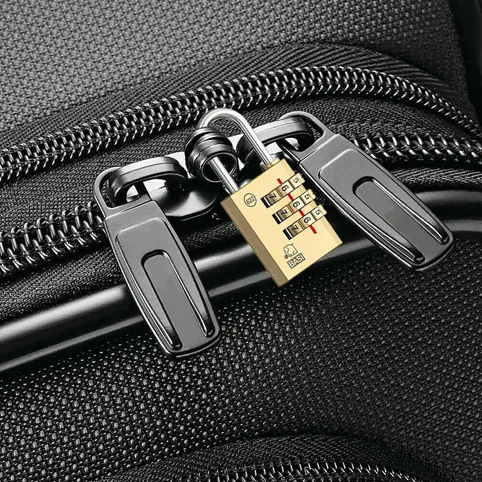 Basi Zahlenschloss KS 622 - L x B: 30 x 21 mm, Bügelstärke: 3 mm, Messing - Goldenes Kombinationsschloss sichert zwei schwarze Reißverschlusszipper an einer schwarzen Strukturtasche.