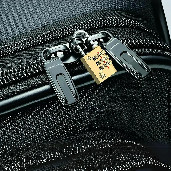 Basi Zahlenschloss VHS 622 - L x B: 40 x 27 mm, Bügelstärke: 5 mm, Messing - Goldenes Zahlenschloss sichert zwei schwarze Reißverschlusszipper an einer dunklen strukturierten Tasche.