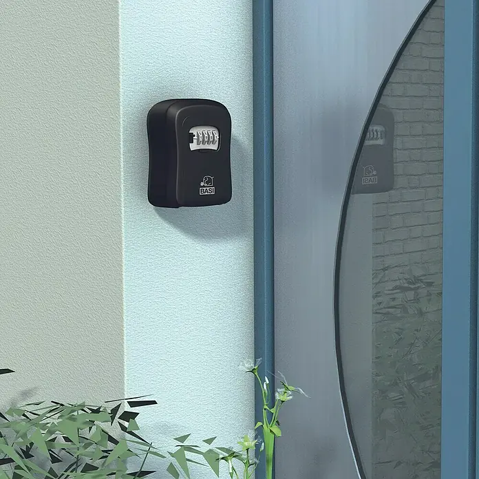 Basi Schlüsselbox SSZ 200 - L x B x H: 40 x 95 x 115 mm, Schwarz - Schwarzer BASI Kombinations-Schlüsselsafe, an einer Wand neben einer Tür montiert.