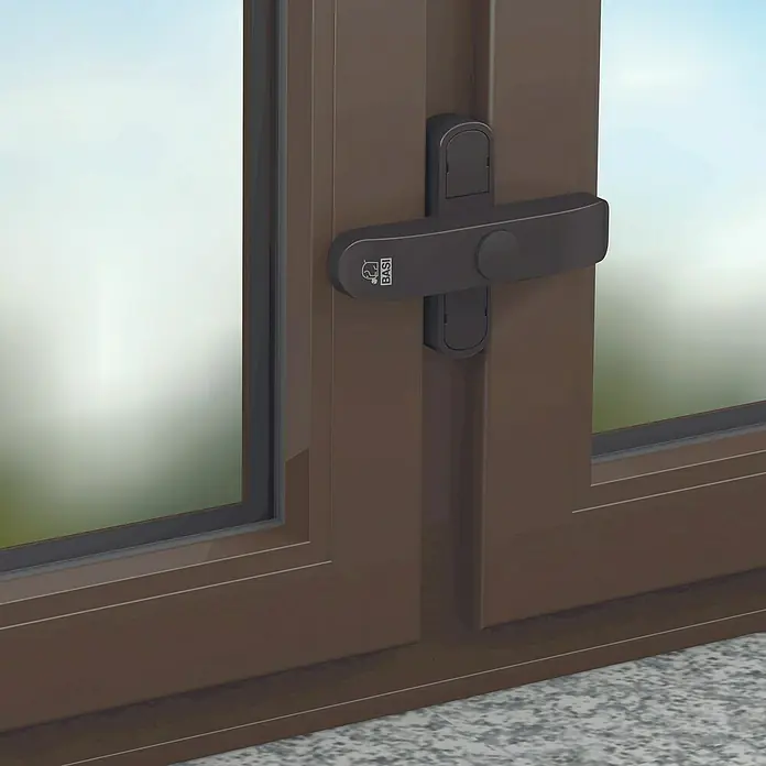 Basi Fenstersicherung FS 500 - Zweiflügelig, Braun - Dunkelgraues BASI Fensterriegel an einem braunen Fensterrahmen.