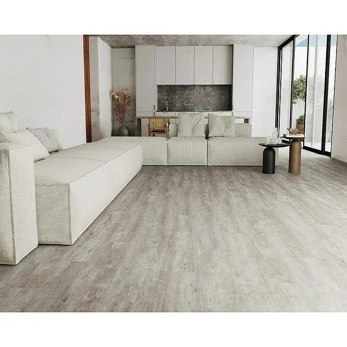 LOGOCLIC Laminado Hidro Roble Titanio 48H Resistente al Agua - 1.200 x 196 x 10 mm, Roble Titanio, AC5, Resistente al agua - Tablas de aspecto de madera gris claro cubren el suelo de una moderna sala de estar con un sofá grande.