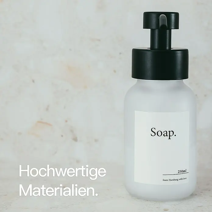 Designfabrik Hamburg Seifenspender - Edelstahl, Schwarz/Satiniertes Glas - Mattweißer Glasspender mit schwarzer Pumpe und weißem Etikett: 'Soap.', '250ml from Hamburg with love.'.