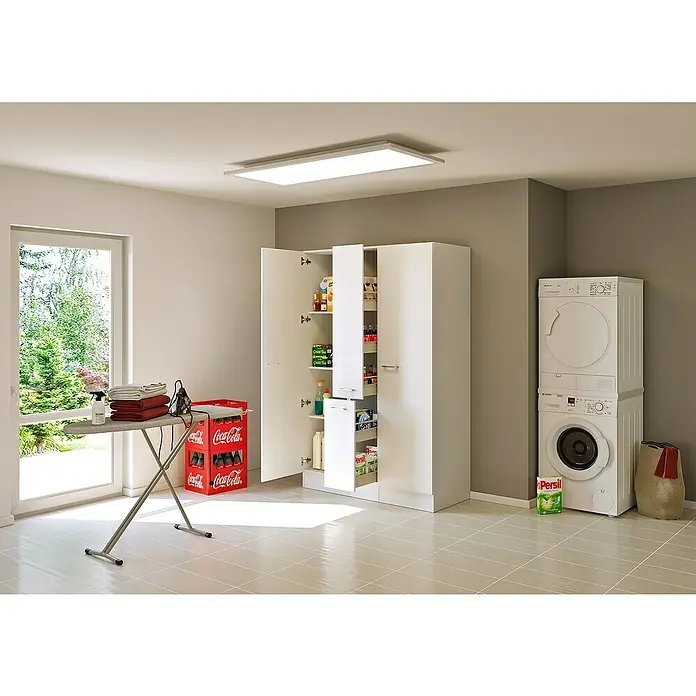 Flex-Well Lucca Mehrzweckschrank Typ 4 - 60 x 130 x 200 cm, Weiß - Ein heller Hauswirtschaftsraum mit weißen Lagerschränken, gestapelter Waschmaschine und Trockner, Bügelbrett und roten Kisten auf hellen Fliesen.