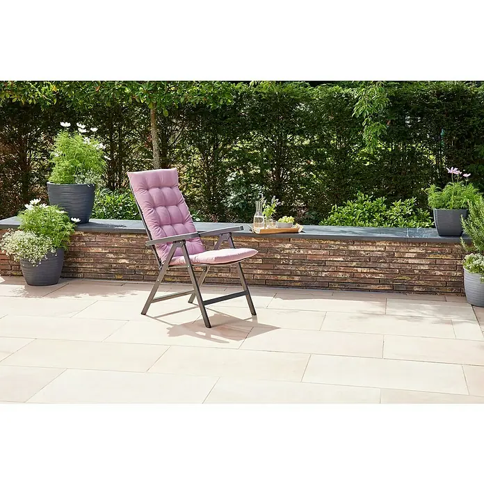 Siena Garden Atria Sitzauflage - L x B x H: 123 x 48 x 6 cm, Altrosa, Polyester, 1 Stk. - Ein dunkelgrauer Gartenstuhl mit rosafarbenem Polster steht auf einer hellen Terrasse, bereit zum Entspannen.