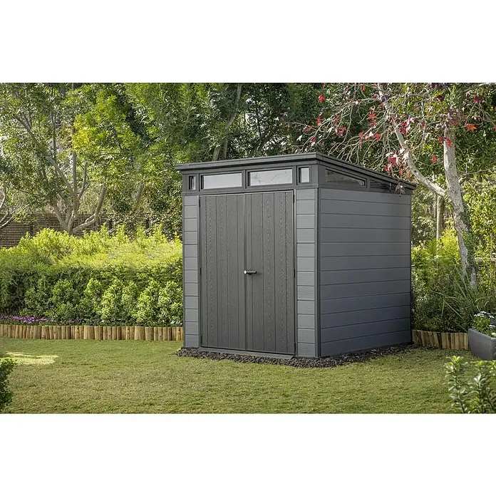 Keter Caseta de jardín Cortina 7x7 - Medidas ext. (An x Pr): 216 x 218 cm, Plástico, Gris, 4,7 m² - Caseta de jardín gris oscuro con puertas efecto madera y laterales panelados, ubicada en un jardín.