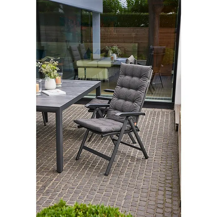 Siena Garden Atria Sitzauflage - L x B x H: 123 x 48 x 6 cm, Anthrazit, Polyester, 1 Stk. - Dunkelgraue Outdoor-Esstischgarnitur mit gepolsterten Stühlen auf einer Terrasse.