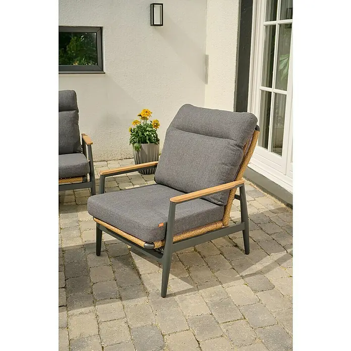 Siena Garden Roma Loungemöbel-Set - 3 -tlg., Grau, Aluminium - Dunkelgrauer Outdoor-Sessel mit Holzarmlehnen und geflochtenen Details auf einer gepflasterten Terrasse.