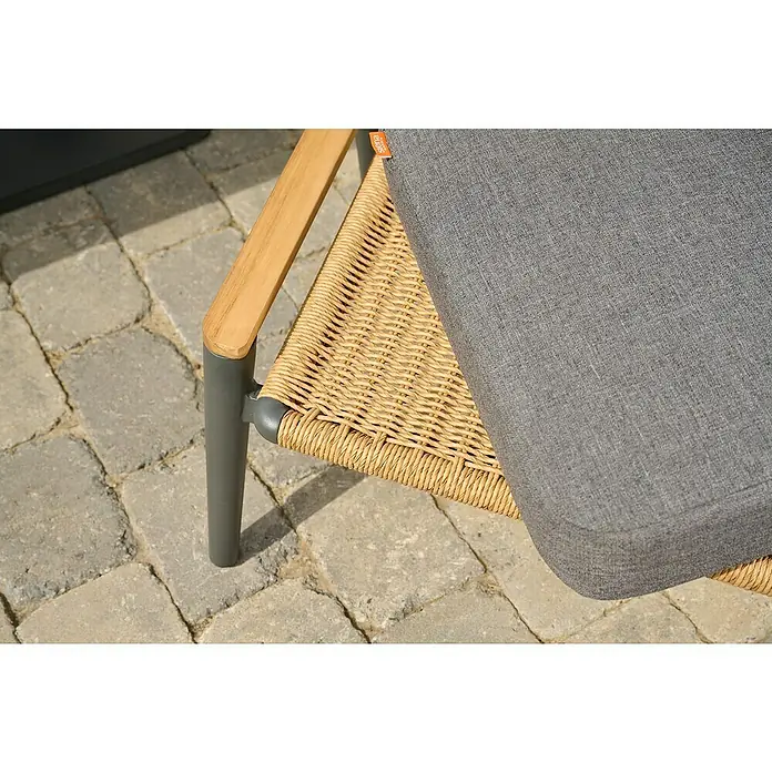 Siena Garden Roma Loungemöbel-Set - 3 -tlg., Grau, Aluminium - Nahaufnahme eines Siena Garden Gartenstuhls mit grauem Kissen, Rattan-Geflecht, Holzarmlehne und grauem Metallgestell auf Steinplatten.