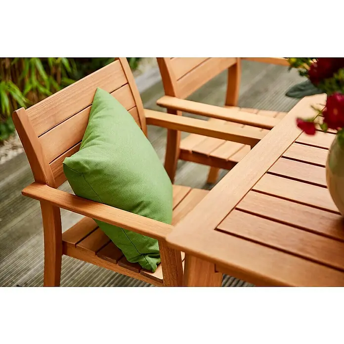 Siena Garden Kissen PRIME - 45 x 45 cm, Grün, Quadratisch - Heller Holz-Gartenstuhl mit hellgrünem Kissen, neben einem passenden Outdoor-Tisch mit Latten.