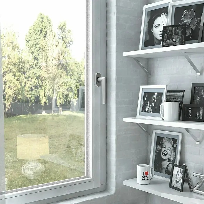 Basi Fenstergriff FG 310 - Edelstahl, Verdeckte Montage - Innenansicht mit weißem Fensterrahmen zum Garten und weißen Regalen an der Wand mit gerahmten Schwarz-Weiß-Fotos und Tassen.