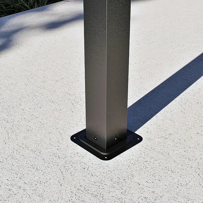 Sojag Standard-Pavillon London 1014 - L x B x H: 424,3 x 299,3 x 310 cm, Aluminium, Schwarz - Nahaufnahme des dunkelgrauen, strukturierten Metallpfostenfußes mit quadratischer Platte, auf heller Außenfläche verankert.