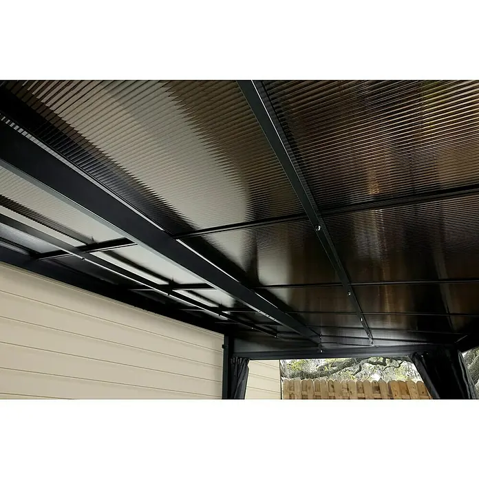 Sojag Terrassenüberdachung St. Barth - L x B x H: 240,4 x 366,8 x 240,2 cm, Metall, Schwarz - Unterseite eines dunklen, gewellten Terrassenüberdachungsdaches mit schwarzen Stützbalken, das einen Außenbereich am Haus beschattet.