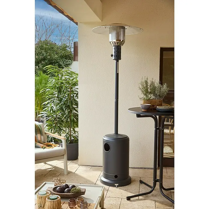 Grillstar Terrassenstrahler Heatwave - 10 kW, Höhe: 221,5 cm - Hoher dunkelgrauer Terrassenheizer auf gefliester Terrasse, spendet Wärme für einen Sitzbereich.