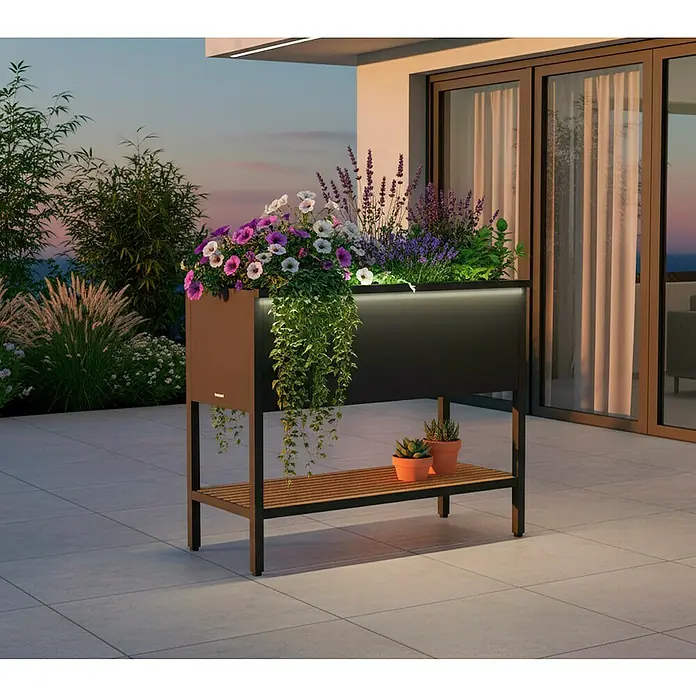 Herstera Garden Hochbeet Deco inkl. LED-Beleuchtung - 40 x 100 x 80 cm, Metall, Anthrazit - Moderner, dunkler Pflanzkasten mit integriertem LED-Licht und Holzablage, gefüllt mit bunten Blumen und Pflanzen auf einer Terrasse.