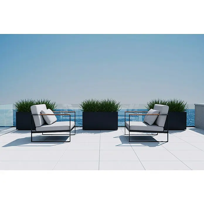 Herstera Garden Pflanzkasten Cube 30 M - Außenmaß (L x B x H): 30 x 100 x 50 cm, Metall, Anthrazit - Zwei moderne Outdoor-Sessel mit weißen Kissen, schwarzen Gestellen und Holzarmlehnen auf einer Terrasse mit Meerblick.