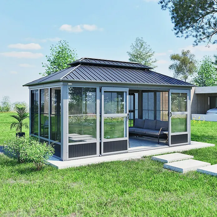 Sojag Standard-Pavillon Olan 1017 - Grau, Schwarz, Metall, L x B x H: 310 x 529,5 x 291 cm - Ein moderner Garten-Wintergarten aus grauem Metall und Glas mit dunkelgrauem Dach auf einer Terrasse in einem Garten, mit einem Sofa innen.