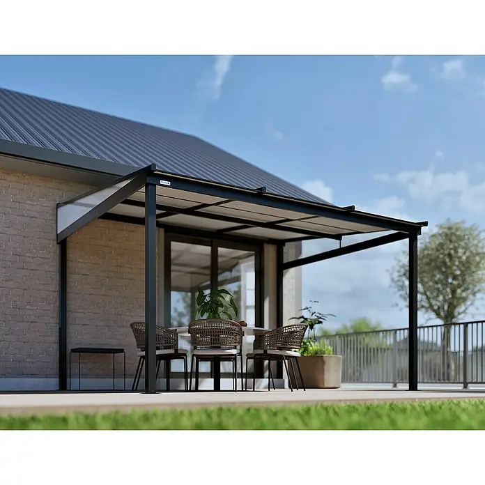 Sojag Terrassenüberdachung Budavar - Schwarz, Metall, L x B x H: 298,5 x 366,5 x 243 cm - Eine moderne Terrassenüberdachung aus schwarzem Metall mit lichtdurchlässigen Dachplatten an einem Ziegelhaus, die einen Essbereich im Freien beschattet.