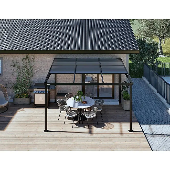 Sojag Terrassenüberdachung Budavar - Schwarz, Metall, L x B x H: 298,5 x 366,5 x 243 cm - Schwarze Pergola mit transparentem Dach über einem Essbereich auf einer Holzterrasse am Haus.