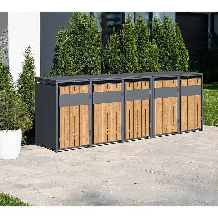 Westmann Mülltonnenbox Varius - Stahl, Anthrazit & Holzoptik, Geeignet für Anzahl Mülltonnen: 5 Stk. - Vier dunkelgraue und helle Holz-Mülltonnenboxen auf einer gepflasterten Terrasse vor grünen Büschen.