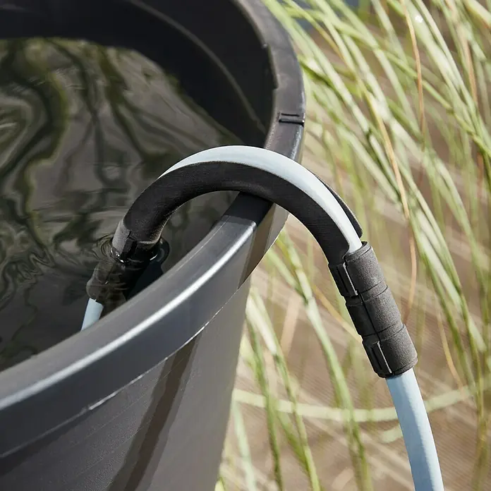 Oase ProMax Rain Regenfasspumpe ProMax Rain - 370 W, 4.000 l/h - Nahaufnahme eines grauen Eimers mit Wasser und einem grauen Schlauch, der über den Rand des Eimers geführt wird.