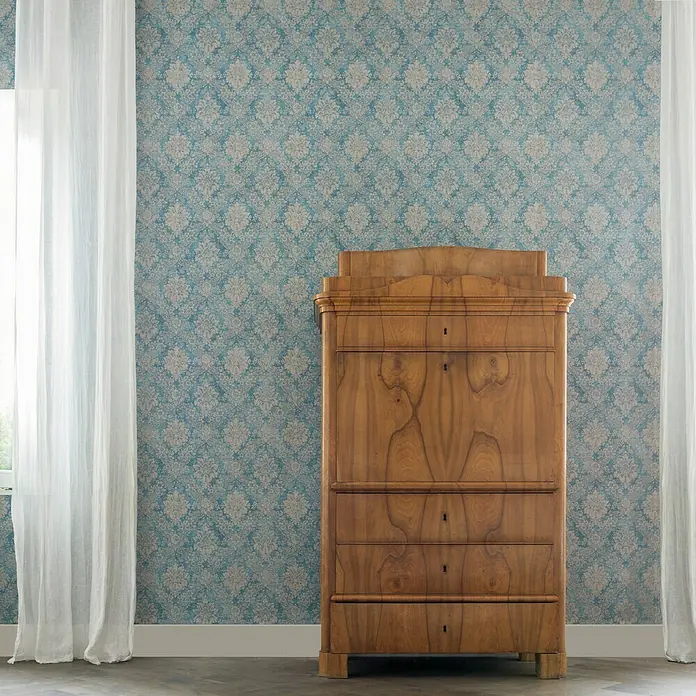 A.S. Création Papel pintado de vellón Secret Garden - Azul/Gris, Floral, 10,05 x 0,53 m - Armario antiguo de madera con cajones, de pie contra una pared azul estampada con cortinas blancas.