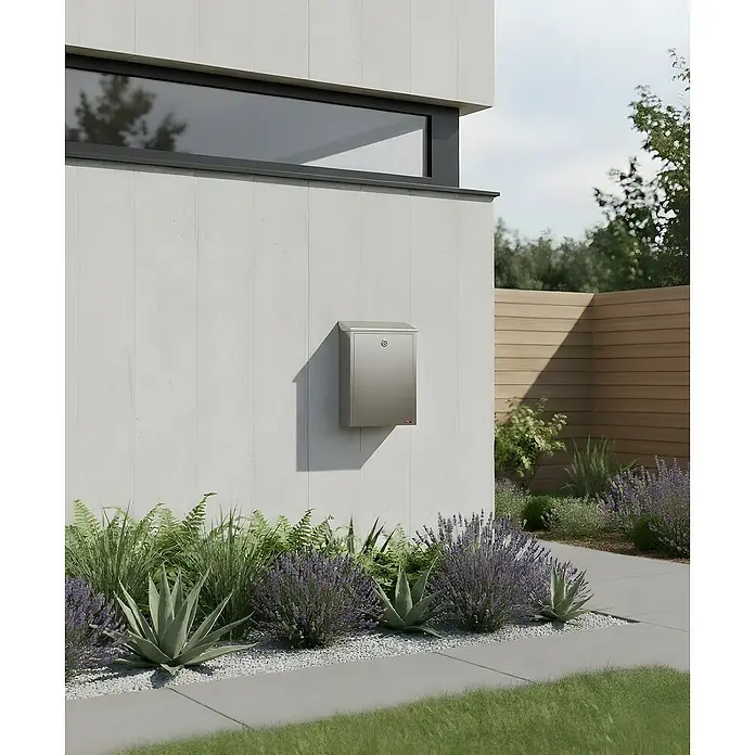 Allux Briefkasten 200 - L x B x H: 140 x 280 x 390 mm, Silber, Stahl - Silberner wandmontierter Briefkasten an einer modernen Gebäudefassade, umgeben von Pflanzen.