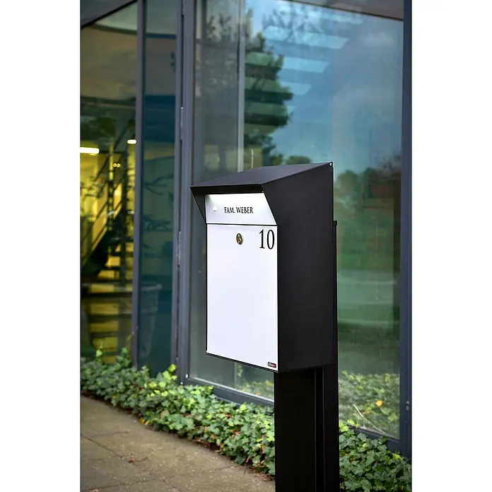 Allux Standbriefkasten BjÃ¶rn Mailbox - L x B x H: 235 x 345 x 525 mm, Grau / Schwarz, Stahl - Moderner schwarz-weißer Briefkasten auf Ständer, mit 'FAM. WEBER' und Nummer '10', im Freien neben einem Gebäude.
