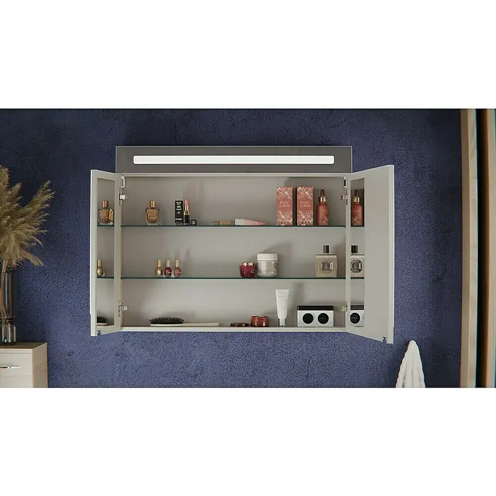 Fackelmann Oxford Badmöbel-Set - Gesamtbreite Badmöbel: 90 cm, Braun Hell, Matt, 3-Teiliges Set mit Spiegelschrank - Weißer Spiegelschrank mit offenen Türen, Glasböden voller Kosmetika, integrierter Lichtleiste. Montiert an einer texturierten blauen Wand.