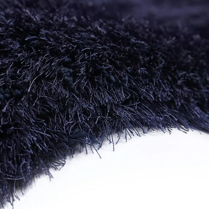 Kayoom Hochflorteppich Cosy - Blau, 290 x 200 cm, 100 % Polyester - Nahaufnahme eines dunkelblauen, zotteligen Teppichs mit langen, feinen Fasern und einem weichen, luxuriösen Aussehen.
