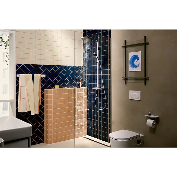 Hansgrohe Duschsystem Activera S - Lochabstand: 138 mm - 162 cm, Anzahl Strahlarten: 2 Stk., Chrom - Modernes Badezimmer mit laufender Chromdusche, weißer Toilette und blauen sowie beigen geometrischen Fliesen.