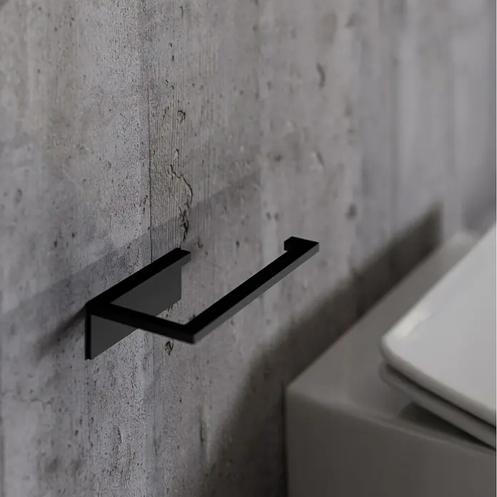 Portarrollos papel higiénico Urban - Acero inoxidable, Negro - Portarrollos negro minimalista montado en pared de hormigón junto a un inodoro.