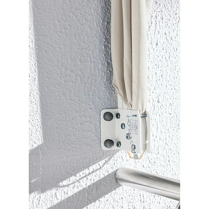 Sunfun Balkonfächer - Beige, 1,4 x 1,4 m - Weiße Wandhalterung mit Metallbolzen und Kette, hält cremefarbenen Faltstoff, neben einer gebürsteten Metallstange.
