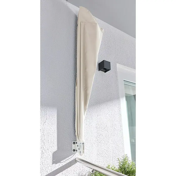 Sunfun Balkonfächer - Beige, 1,4 x 1,4 m - Beiges aufrollbares Seitenrollo, eingefahren, an einer strukturierten Außenwand montiert.