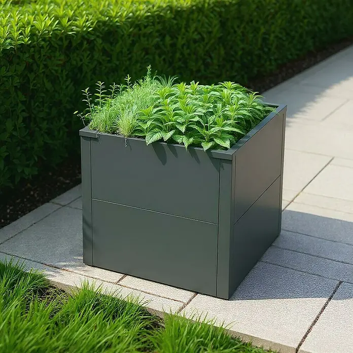 Metzler Hochbeet - 50 x 50 x 50 cm, Stahl, Eisenglimmer - Dunkelgrauer rechteckiger Pflanzkübel mit üppigen grünen Pflanzen auf einer gepflasterten Terrasse.