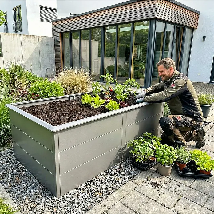Metzler Hochbeet - 206 x 106 x 77 cm, Stahl, Grau - Graues Metall-Hochbeet in modernem Garten, Mann pflanzt Setzlinge.