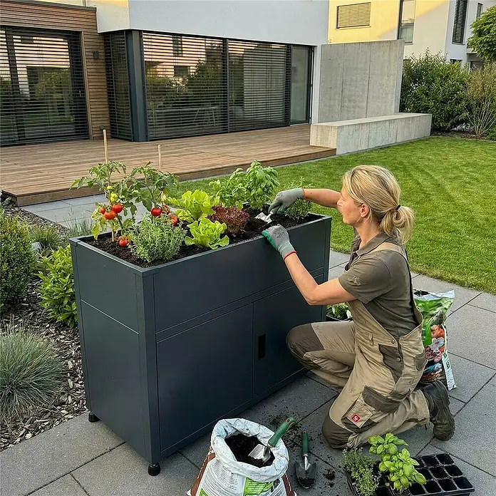 Metzler Hochbeet mit Stauraum - 100 x 50 x 90 cm, Stahl, Anthrazit - Dunkelgraues Hochbeet mit Stauraum, genutzt zum Anbau von Gemüse und Kräutern im Garten.