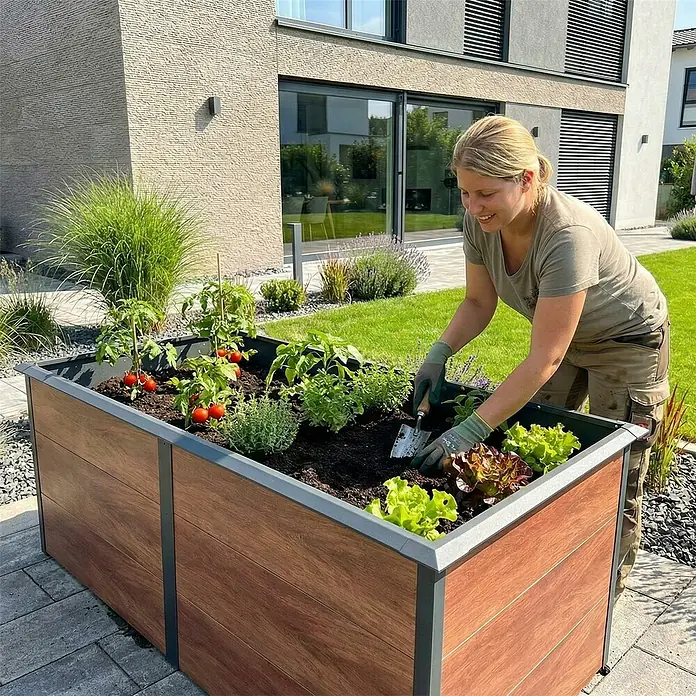 Metzler Hochbeet - 206 x 106 x 77 cm, Stahl, Anthrazit/Braun - Hochbeet aus Holzoptik und dunkelgrauem Metall, bepflanzt und von einer Person im modernen Garten genutzt.