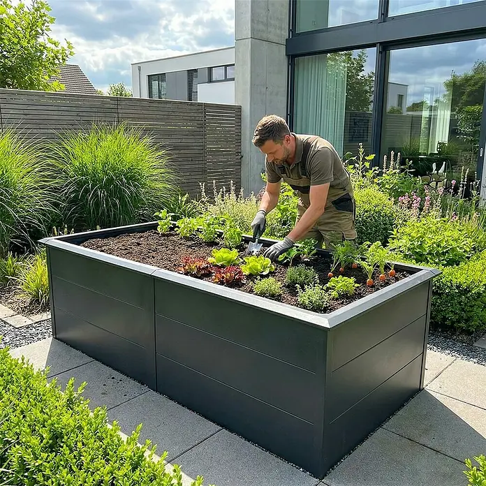 Metzler Hochbeet - 206 x 106 x 77 cm, Stahl, Eisenglimmer - Ein dunkelgraues Hochbeet, gefüllt mit Pflanzen, in dem ein Mann in einer modernen Gartenumgebung gärtnert.