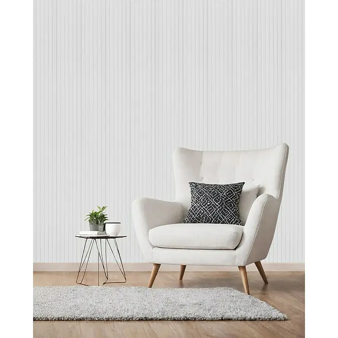 Lautloz Akustikpaneel Coverz - Weiß, 20 x 240 cm, Textil - Cremefarbener Sessel mit Holzbeinen und gemustertem Kissen, in einem Wohnzimmer mit Beistelltisch und Teppich.