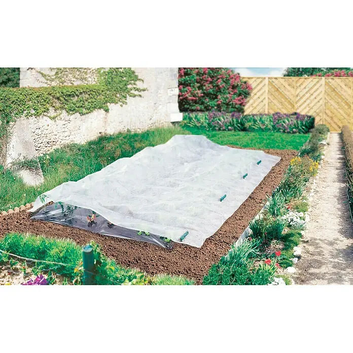 Nortene Film transparente crecimiento Climatex - L x An: 10 x 2 m, Blanco - Imagen de una parcela de jardín cubierta con una manta térmica, utilizada para proteger las plantas y alargar la temporada de cultivo.
