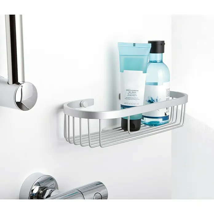 Tatay Cesta de baño oval Ice -  - Estante de ducha plateado con dos productos para el cuidado de la piel en un baño moderno.