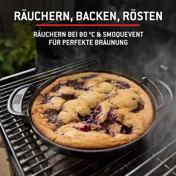 Weber Smoker Smoque - Grillfläche (B x T): 56 x 44,5 cm, Schwarz - Gusseisenpfanne mit gebackenem Blaubeerdessert auf einem Grill, mit Rauch.