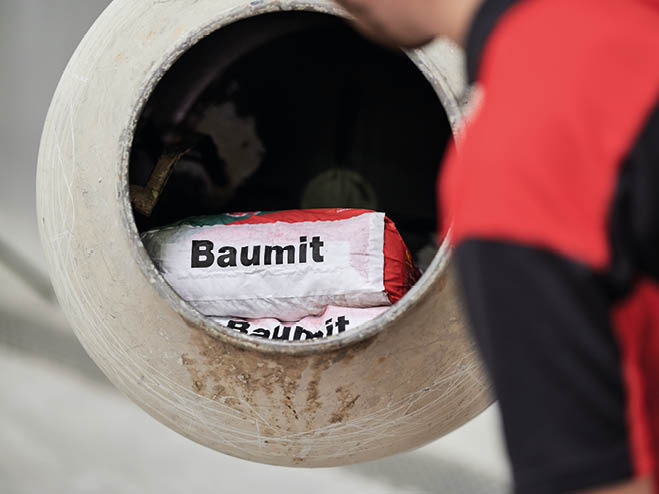 Mann mischt BAUMIT ALL IN Beton im Betonmischer an