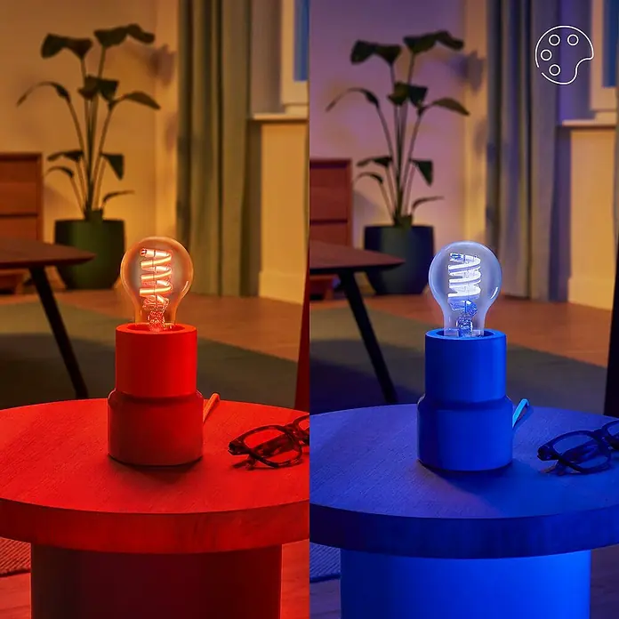 Philips Wiz Smart-LED-Lampe - E27, Dimmbar, RGBW, 470 lm, 6,3 W, 1 Stk. - Smarte LED-Birne in dekorativer Tischlampe, in rotem und blauem Licht gezeigt, demonstriert Farbwechsel.