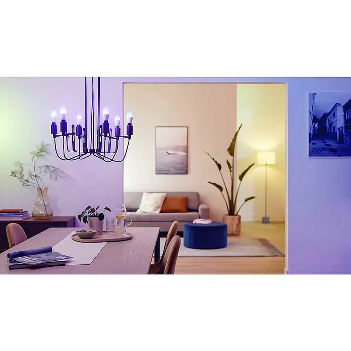 Philips Smart-LED-Lampe - E14, Dimmbar, RGBW, 470 lm, 4,9 W, 2 Stk. - Schwarzer Kronleuchter mit smarten Glühbirnen beleuchtet einen Essbereich mit farbigem Licht.