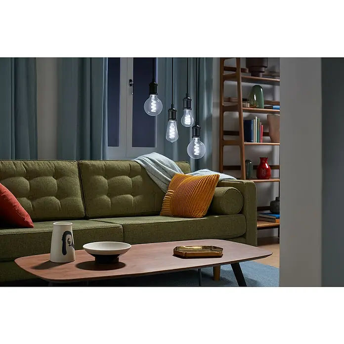 Philips Wiz Smart-LED-Lampe - E27, Dimmbar, RGBW, 470 lm, 6,3 W, 1 Stk. - Vier beleuchtete, dekorative LED-Glühbirnen mit Wendelfilamenten, die in einem gemütlichen Wohnzimmer hängen.